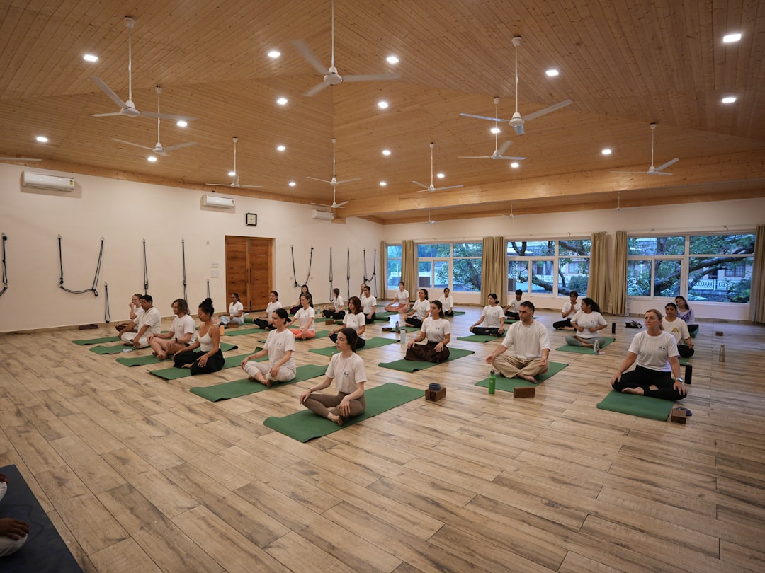 Group meditation class at ANAND YOGA — students seated together in stillness